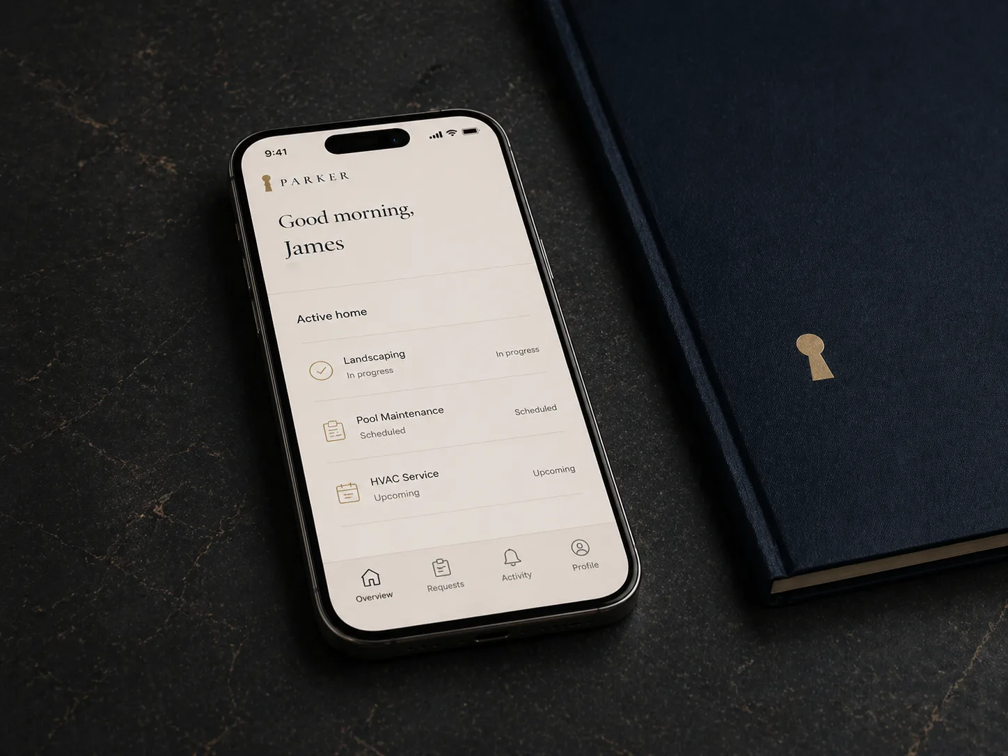 Parker portal on phone resting on a navy leather folio with an embossed gold keyhole